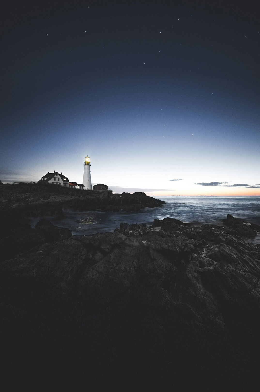 Lonely lighthouse on a cliff at dusk suggesting a mystery novel setting